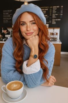 Woman with red hair and a blue beret smiling in a coffee shop