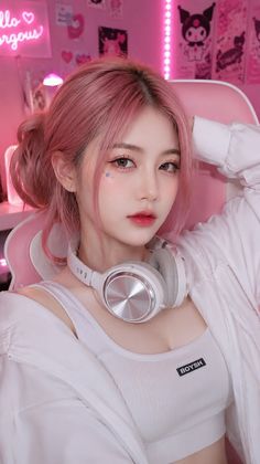 Woman with pink hair and headphones in a pink-lit room