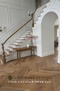 Modern interior with a wooden herringbone floor and a white staircase
