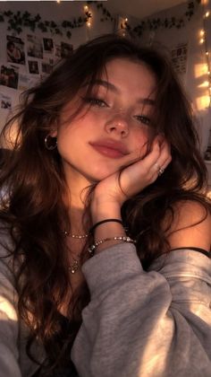 Young woman with long hair and freckles, illuminated by warm, soft lighting