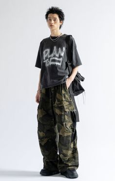 Person with spiky hair wearing an oversized t-shirt and camouflage pants