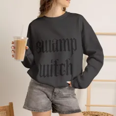 Woman in a black sweatshirt and denim shorts holding an iced coffee