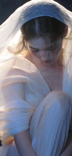 Woman draped in sheer fabric with soft lighting and a dreamy atmosphere