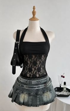 Mannequin wearing a black lace top and a denim pleated skirt with a shoulder bag