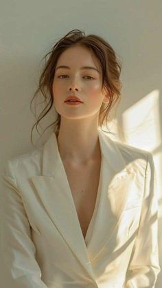 Woman in a white blazer with soft lighting and warm tones