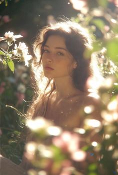 Woman with long hair surrounded by flowers with soft backlight
