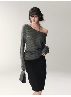 Woman in an off-shoulder striped top and black skirt holding a small handbag