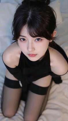 Woman in a black top and thigh-high stockings in a provocative pose