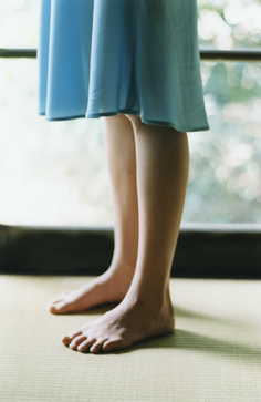 Bare feet on a tatami mat with a blue dress and soft lighting