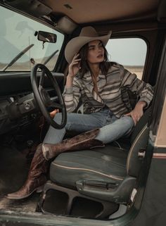Woman in a cowboy hat and boots sitting in a car