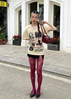 Woman with braided hair wearing a graphic t-shirt, mini skirt, and lace tights on a street