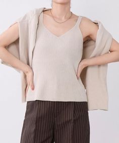 Woman in a ribbed tank top, cardigan, and pinstripe pants