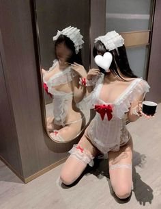 Woman in a white maid lingerie outfit kneeling with a mirror reflection