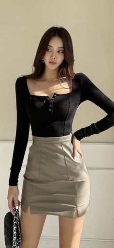 Woman with long hair wearing a black top and mini skirt indoors