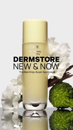 Oribe Hair Alchemy product with white flowers, citrus fruit, and wood on a reflective surface