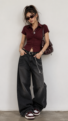 Woman in a cropped maroon top and baggy jeans with a high ponytail