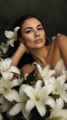 Woman with a white lily in her hair, surrounded by white lilies