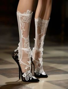 Close up of legs wearing black high heels and white lace stockings