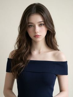 Woman with long brown hair wearing an off-shoulder top, looking directly at the viewer
