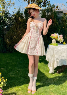 Woman in a floral dress and straw hat standing in a sunny garden