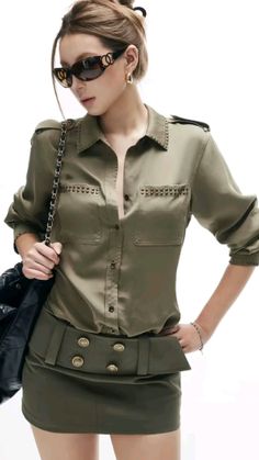 Woman in a khaki shirt and mini skirt with sunglasses and a black handbag