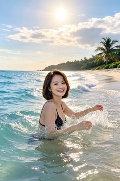 Woman in a black bikini splashing in the ocean at golden hour