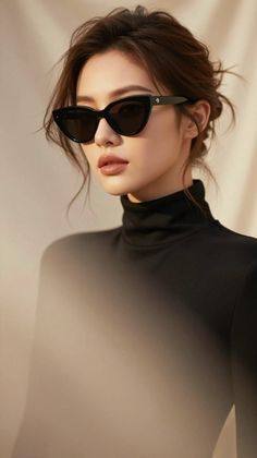 Woman in a black turtleneck and sunglasses with a messy bun