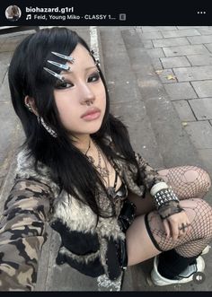 Woman in goth fashion with fishnet stockings and dark makeup sitting outdoors
