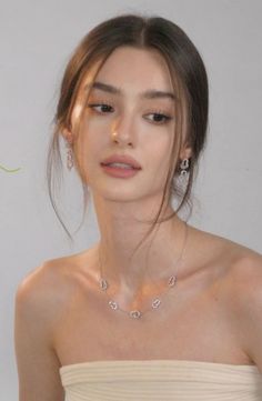 Woman with long hair wearing jewelry and a strapless top
