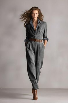 Woman in a plaid jumpsuit with a brown belt and flowing hair in a studio