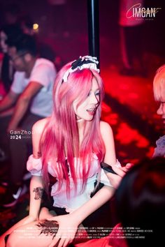 Woman with pink hair in a maid costume at a nightclub