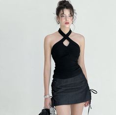 Woman in a black halter top and mini skirt with an updo hairstyle