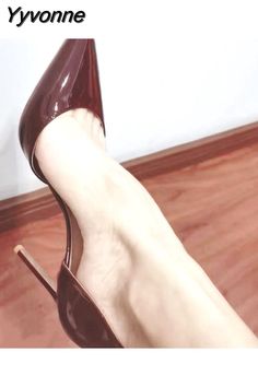 Close up of a foot in a dark red patent leather high heel