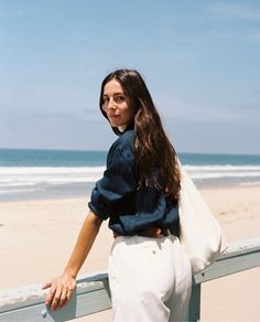Woman with long hair on a beach looking over her shoulder