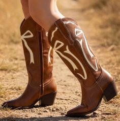 Close up of brown cowboy boots with white stitching outdoors