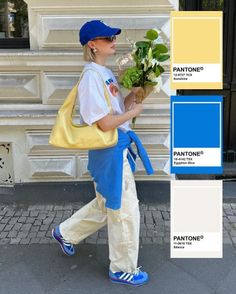 Person in a blue cap and sunglasses holding flowers on a street