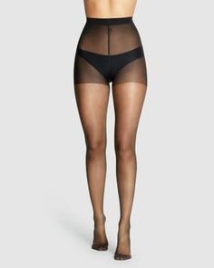 Woman wearing sheer black pantyhose and black underwear in a studio shot