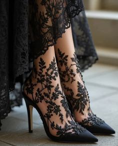 Close up of feet in black lace high heels with floral embroidery
