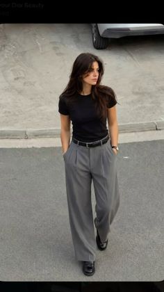 Woman with long hair wearing a black t-shirt and wide leg pants outdoors