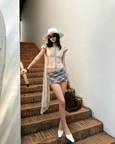 Woman in a white hat and mini skirt standing on brick stairs