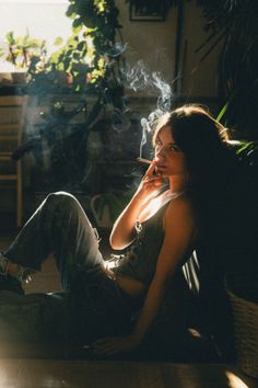 Woman with long hair smoking a cigarette indoors with dramatic backlight