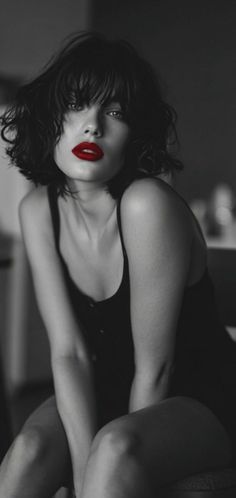 Woman with short dark hair and red lipstick in a black and white photograph
