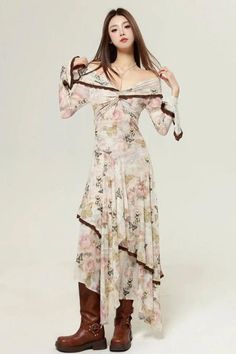 Woman in a floral off-shoulder dress and brown boots posing in a studio
