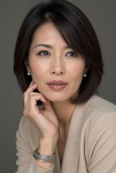 Woman with short hair and pearl earrings wearing a beige blazer