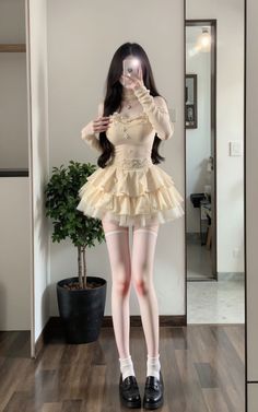 Woman in a ruffle dress and thigh high socks taking a mirror selfie