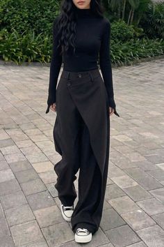 Woman in a black turtleneck and wide leg pants walking outdoors