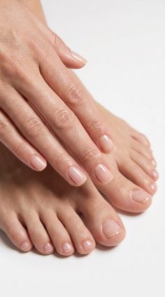 Close up of a person's hands and feet with natural, manicured nails