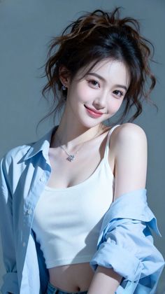 Woman with a messy bun wearing a white tank top and blue shirt in a studio