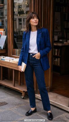 Woman in a blue plaid blazer and jeans standing outside a bookstore