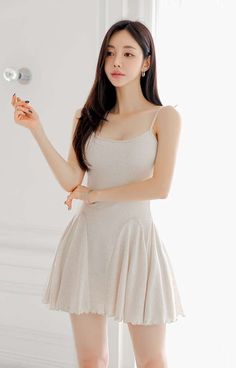 Woman in a light-colored mini dress posing indoors